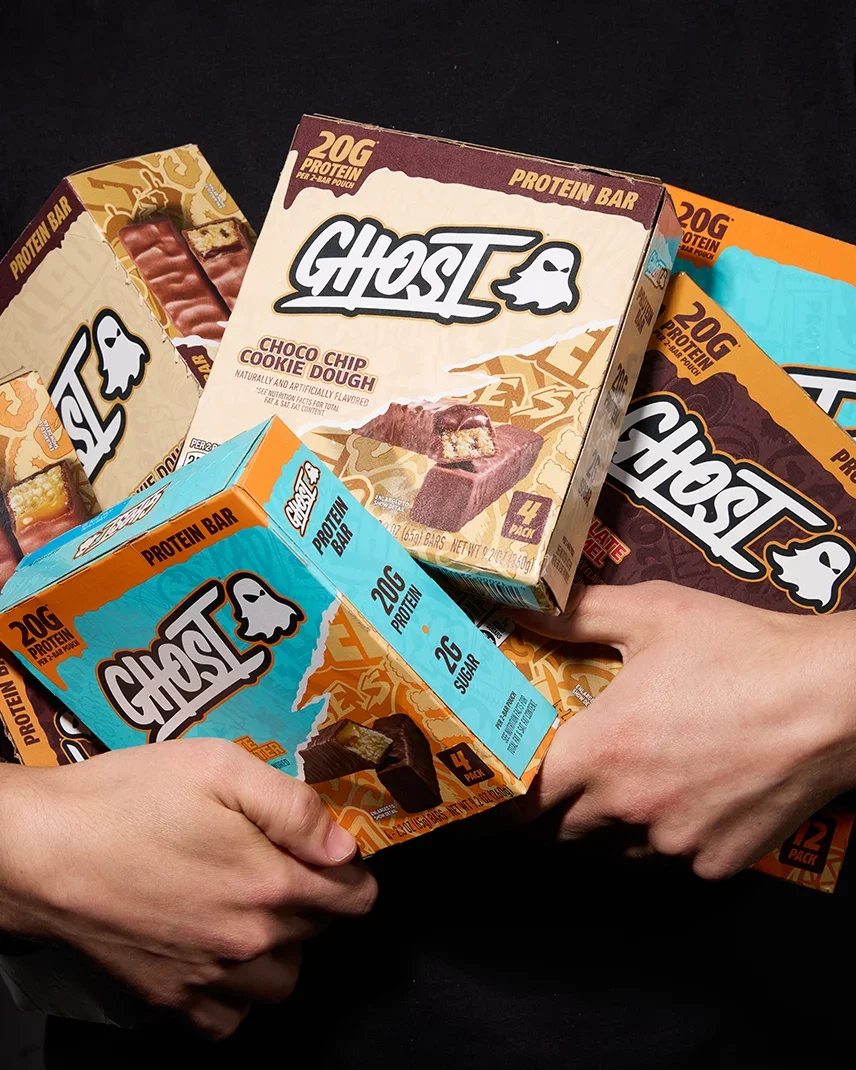 Hands full of GHOST® PROTEIN BAR boxes