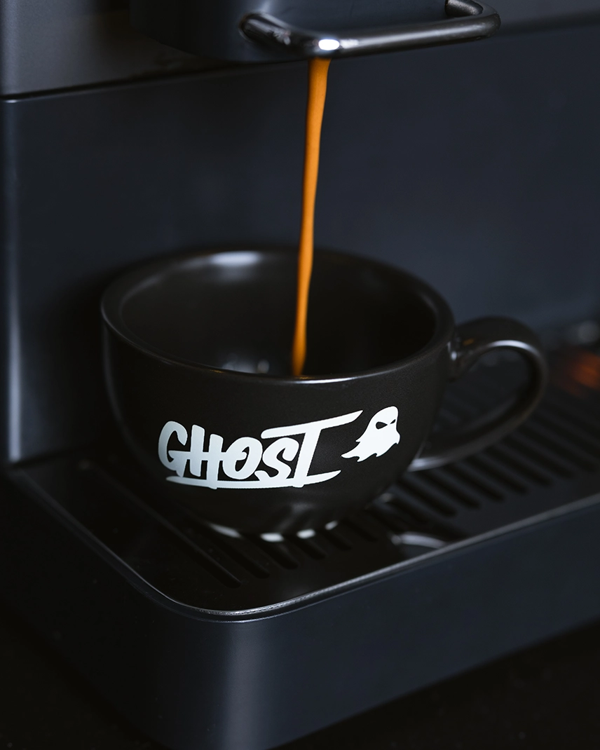 Espresso pouring into a black GHOST® cup